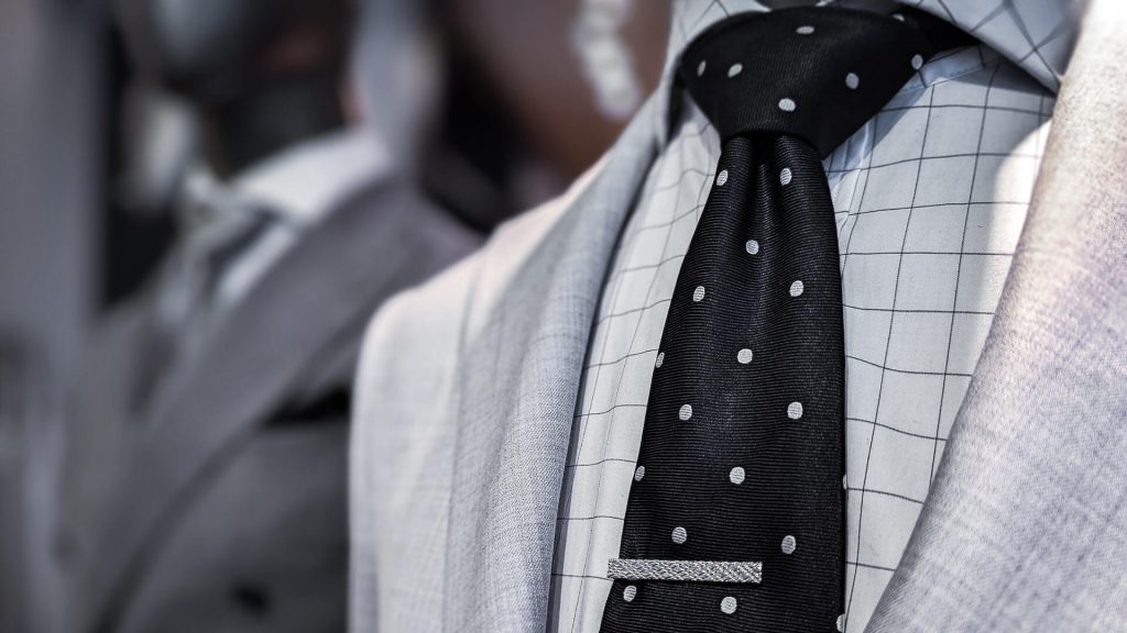 Un completo con cravatta nera e pois bianchi, che unisce l'eleganza a un tocco di allegria