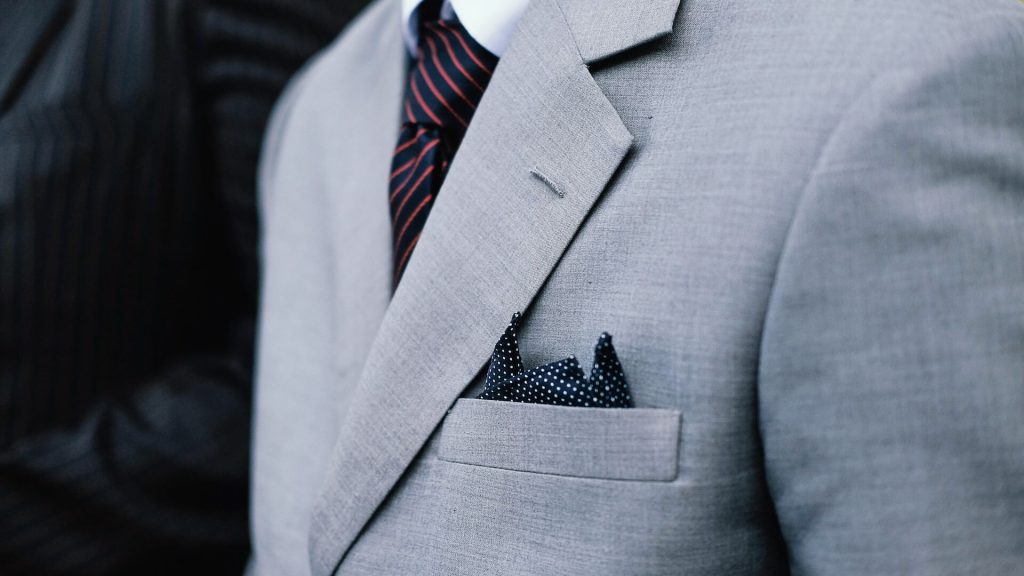 Una giacca classica ornata da un fazzoletto da taschino ripiegato, che aggiunge un tocco di eleganza all'insieme.